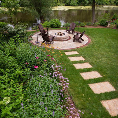 This is an example of a small traditional partial sun backyard stone landscaping in Milwaukee with a fire pit for summer.