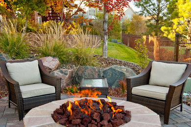 Patio - mid-sized rustic backyard stone patio idea in Denver with a fire pit