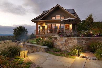 Photo of a huge rustic full sun backyard stone retaining wall landscape in Burlington for summer.