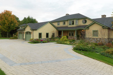 Photo of a huge contemporary partial sun front yard brick driveway in Burlington for spring.