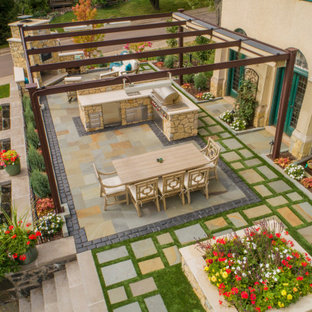 Geometrischer, Kleiner Klassischer Garten im Sommer, hinter dem Haus mit Kamin, direkter Sonneneinstrahlung und Natursteinplatten in Sonstige