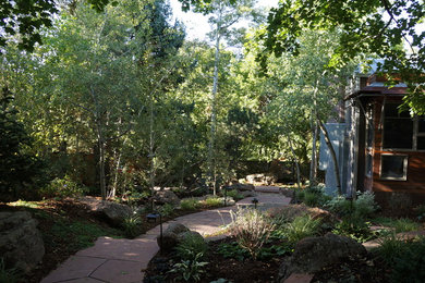 Immagine di un giardino tradizionale esposto a mezz'ombra di medie dimensioni con un ingresso o sentiero, un pendio, una collina o una riva e pavimentazioni in pietra naturale