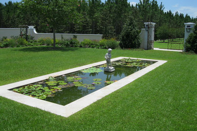 Modelo de jardín clásico en patio trasero con fuente y exposición total al sol