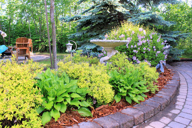 This is an example of a mid-sized contemporary partial sun backyard concrete paver landscaping in Edmonton.
