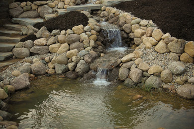 Inspiration for a large traditional partial sun backyard stone landscaping in Other for summer.