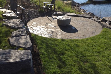 This is an example of a mid-sized craftsman backyard brick landscaping in Dublin with a fire pit.