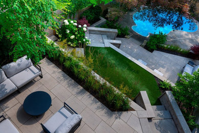 Imagen de jardín actual de tamaño medio en patio trasero con adoquines de piedra natural