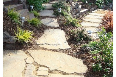 Photo of a mid-sized mediterranean drought-tolerant and full sun backyard stone retaining wall landscape in San Francisco for summer.
