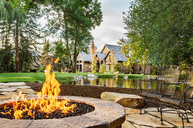 This is an example of a huge traditional front yard stone landscaping in Salt Lake City with a fire pit.