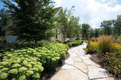 Large classic side formal full sun garden in Boston with a garden path and natural stone paving.