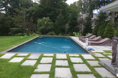 Imagen de piscina contemporánea grande en patio trasero con adoquines de piedra natural