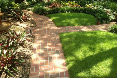 This is an example of a mid-sized traditional partial sun side yard brick landscaping in Tampa.