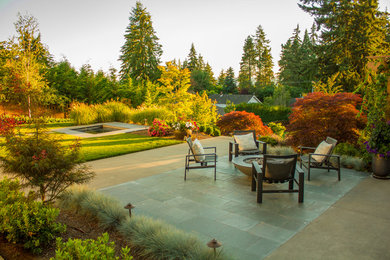 This is an example of a large contemporary full sun backyard stone formal garden in Seattle with a fire pit.
