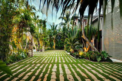 Modelo de acceso privado tropical de tamaño medio en patio delantero con adoquines de piedra natural