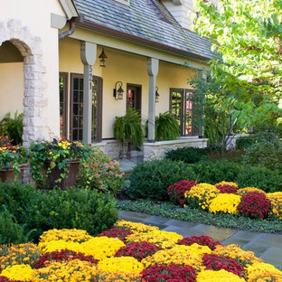 Photo of a traditional front yard stone flower bed in Chicago.