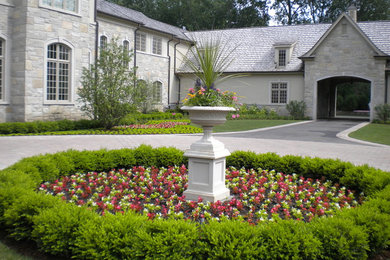 Large traditional front driveway full sun garden in Chicago with natural stone paving.