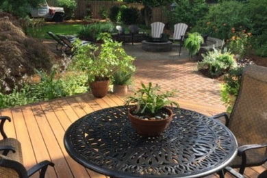 Imagen de jardín clásico grande en patio trasero con brasero, exposición parcial al sol y adoquines de hormigón