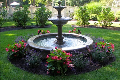Bild på en mycket stor funkis trädgård i delvis sol, med en fontän