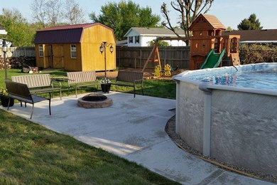 This is an example of a traditional backyard concrete paver water fountain landscape in Other.