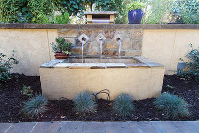 This is an example of a modern partial sun backyard concrete paver retaining wall landscape in Salt Lake City.