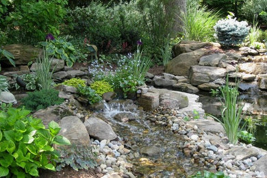 クリーブランドにある高級な広い、春のラスティックスタイルのおしゃれな裏庭 (池、日陰、砂利舗装) の写真