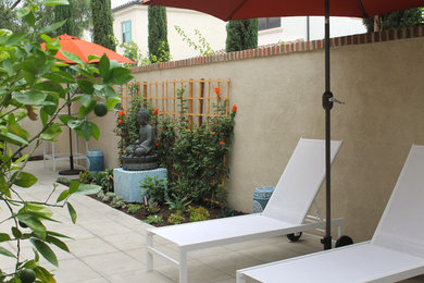 Photo of a small contemporary partial sun and drought-tolerant backyard concrete paver landscaping in Orange County.