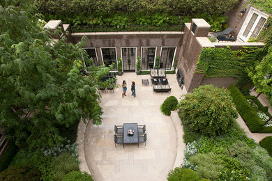 Modelo de jardín contemporáneo grande en patio con jardín francés y muro de contención
