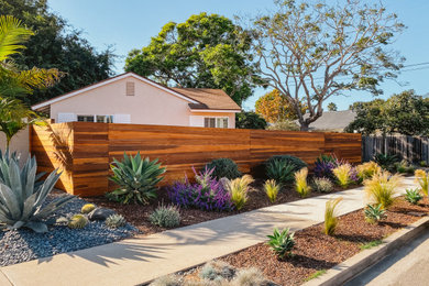 Photo of a large contemporary full sun side yard river rock landscaping in Santa Barbara.