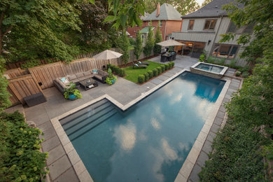 This is an example of a mid-sized contemporary backyard stone landscaping in Toronto.