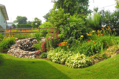 This is an example of a mid-sized traditional full sun backyard stone water fountain landscape in Philadelphia for summer.
