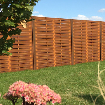 Corten metal fencing panels. A familiar post and panel fencing system in a uniqu