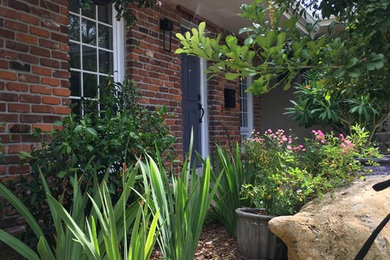 На фото: маленький солнечный, летний регулярный сад на переднем дворе в классическом стиле с садовой дорожкой или калиткой, хорошей освещенностью и покрытием из гравия для на участке и в саду с