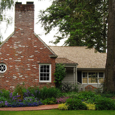 Inspiration for a traditional front yard brick flower bed in Portland.
