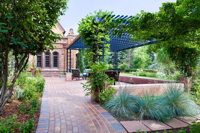 Immagine di un grande giardino chic esposto in pieno sole dietro casa con pavimentazioni in mattoni