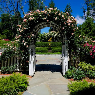Immagine di un grande giardino formale chic nel cortile laterale con un focolare e pavimentazioni in mattoni