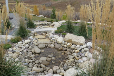 Idée de décoration pour un grand jardin arrière tradition l'automne avec un bassin et des pavés en béton.