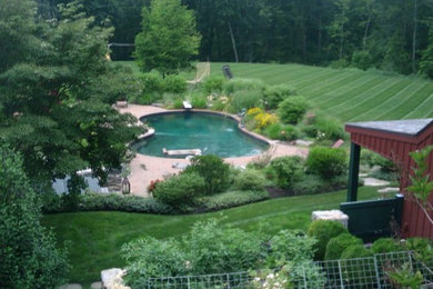 Immagine di un ampio giardino country esposto a mezz'ombra dietro casa in estate con fontane e pavimentazioni in cemento