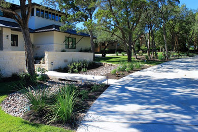Modelo de acceso privado contemporáneo grande en primavera en patio delantero con exposición parcial al sol y adoquines de piedra natural