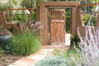 Photo of a large mediterranean front xeriscape partial sun garden for summer in Los Angeles with natural stone paving.