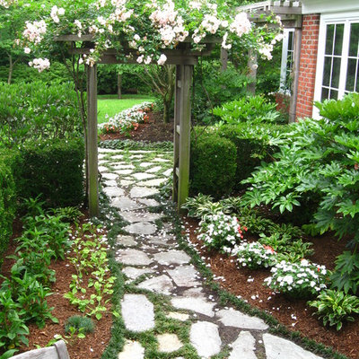 This is an example of a large traditional partial sun backyard stone garden path in Other for summer.