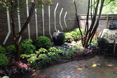 Inspiration for a small contemporary shade backyard water fountain landscape in Chicago.