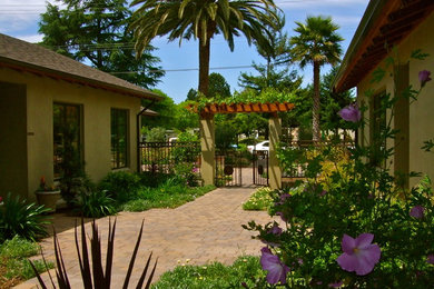 Immagine di un giardino mediterraneo esposto a mezz'ombra di medie dimensioni e in cortile in estate con un ingresso o sentiero e pavimentazioni in cemento