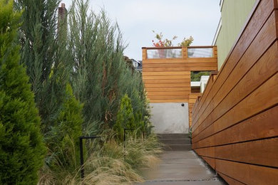 This is an example of a small mid-century modern full sun courtyard concrete paver landscaping in Seattle.
