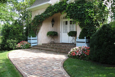 Photo of a mid-sized traditional front yard brick landscaping in Other.