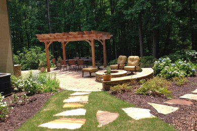 This is an example of a mid-sized traditional shade backyard concrete paver landscaping in Atlanta with a fire pit.