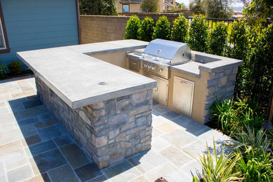 Exemple d'une terrasse arrière avec des pavés en pierre naturelle.