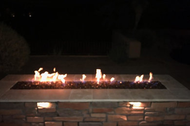 This is an example of a large backyard brick landscaping in Phoenix with a fire pit for winter.