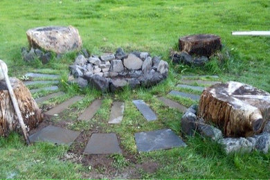 Ejemplo de jardín rústico de tamaño medio en verano en patio trasero con brasero, exposición total al sol y adoquines de piedra natural