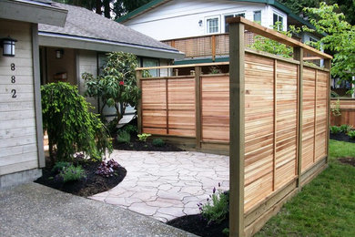 Inspiration for a small modern privacy and full sun front yard stone and wood fence landscaping in Vancouver for summer.
