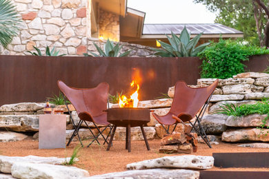 Inspiration for a large contemporary drought-tolerant and partial sun side yard gravel landscaping in Austin with a fire pit for fall.